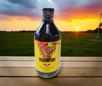 Vigorton 2 Iron & Vitamin Tonic 500mL bottle on outdoor table with sunset background — enriched with Iron, B₂, B₆, B₁₂, Niacinamide, Caffeine & Alcohol for energy and vitality. Jamaican tonic available online in Canada.